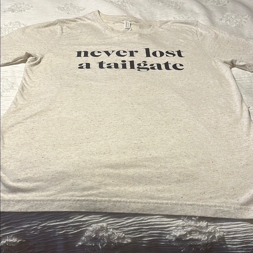 Never worn t shirt “ never lost a tail gate”. Size large PTP 21